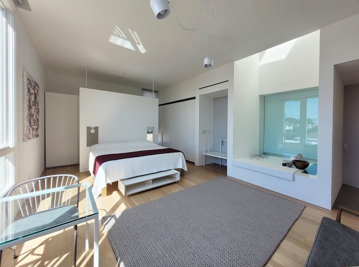 Spálňa a bývanie sú súčasťou rovnakého štedrého priestoru.  Manželská posteľ má veľmi pohodlný matrac Leesa (hybridná pružina a pamäťová pena) a posteľnú bielizeň California Den s vysokým počtom vlákien.