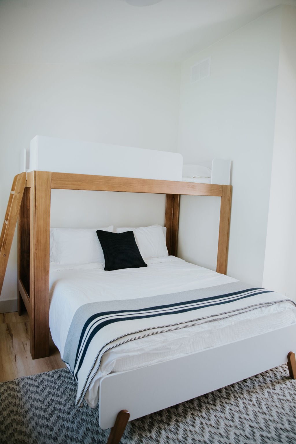 Our third bedroom has a TV, Queen bed, single loft bed above, and a portable fan stored in the closet.