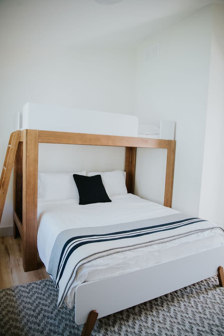 Our third bedroom has a TV, Queen bed, single loft bed above, and a portable fan stored in the closet.