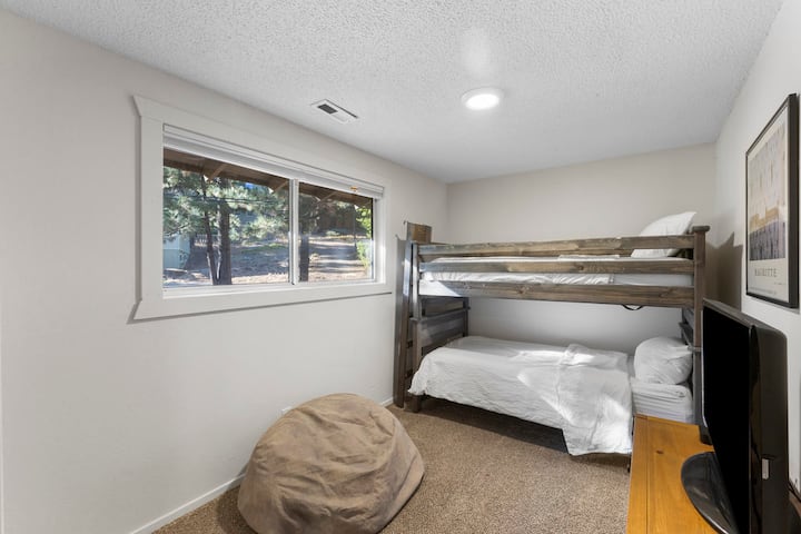 ห้องเตียงสองชั้นชั้นบนพร้อมบีนแบ็กจอแบนและแอปเปิลทีวีซึ่งเป็นพื้นที่พักผ่อนที่ยอดเยี่ยมสำหรับเด็กๆ