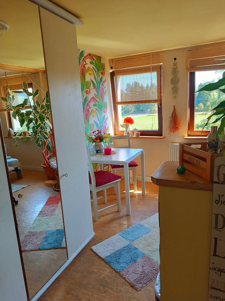 La chambre d'hôtes avec table et chaises avec vue sur le jardin.