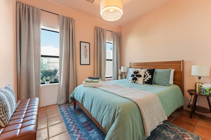 Cozy bedroom with a modern desert vibe! Features a queen bed with soft linens, terracotta tiles, and a stylish rug. Enjoy natural private lighting, a leather bench, and a ceiling fan for comfort. Perfect for a relaxing stay!