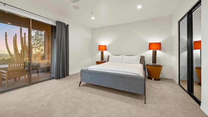 Modern bedroom with an upholstered bed, scenic balcony views, and an implied en suite for added comfort.