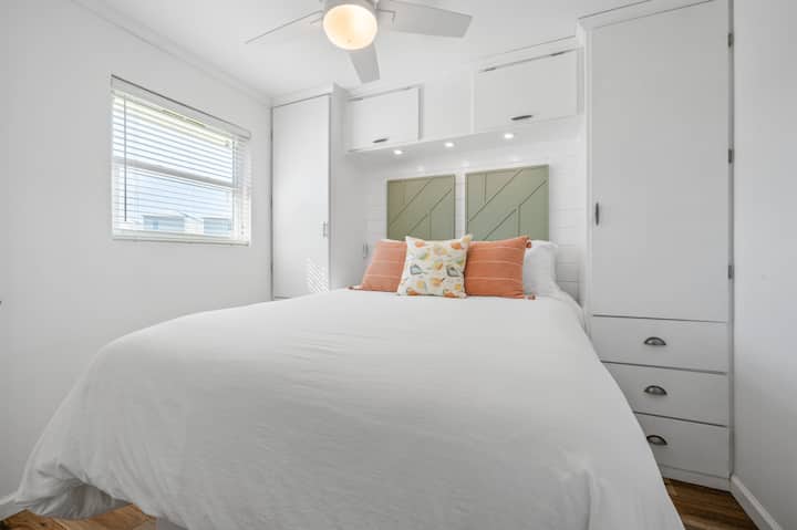 Chumba cha kulala cha msingi kilicho na mashuka ya juu, feni ya dari, televisheni mahiri na bafu la kujitegemea lililounganishwa.