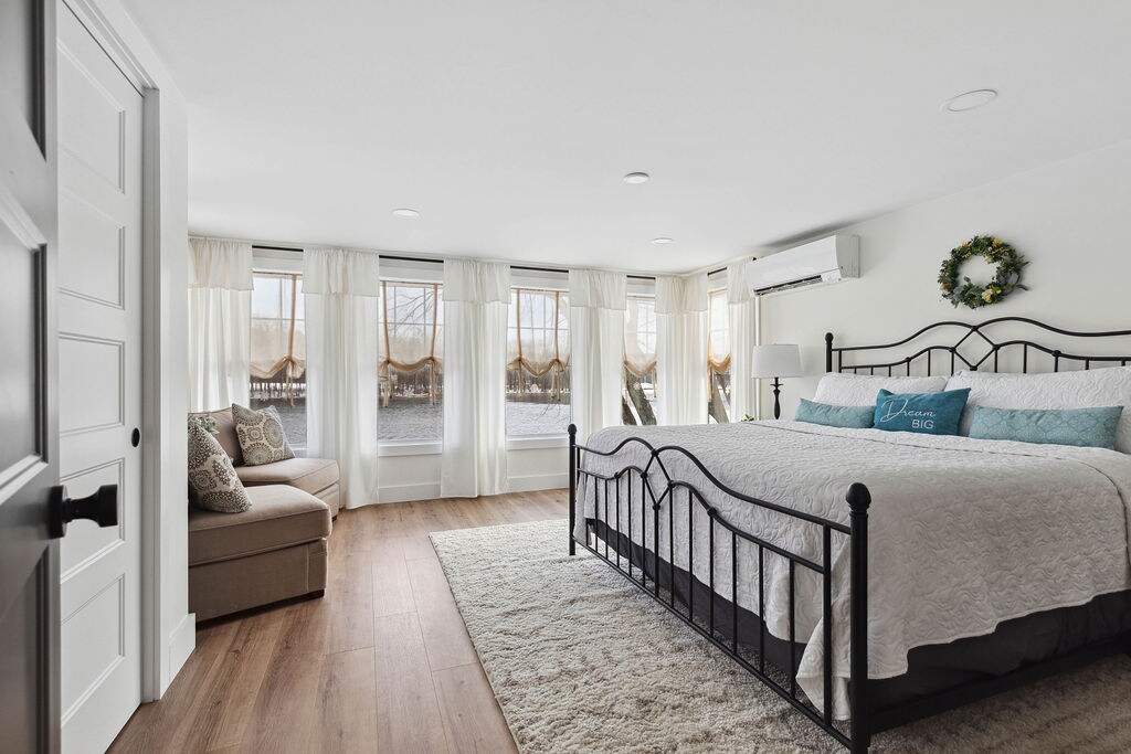 Chumba kikubwa cha kulala chenye nafasi kubwa kinachoangalia maji chenye bafu lake mwenyewe.