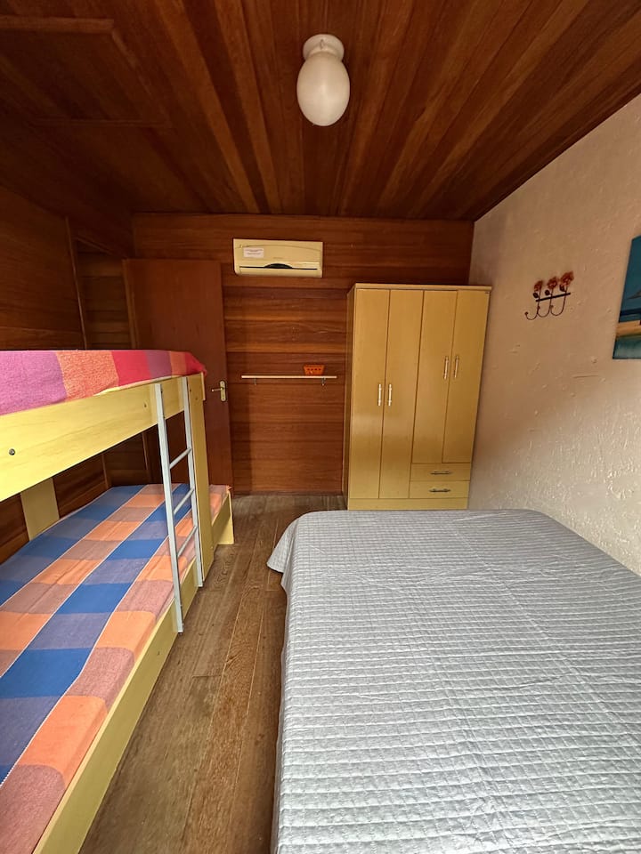 غرفة تقع في الطابق العلوي مع سرير مزدوج وسرير بطابقين وخزانة ملابس وتكييف هواء. 