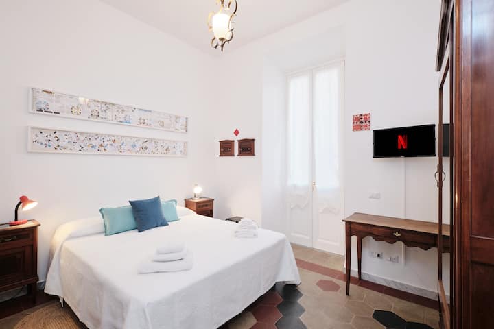 Chambre avec lit double, dimensions 170x200cm.
Armoire avec miroir et tables de chevet originales des années 1920 (Liberty), en bois.
Œuvres sur les murs de Massimo Orsi (Alexandrie, 1962) et Luigi Rossini (gravure, Rome 1790-1857).