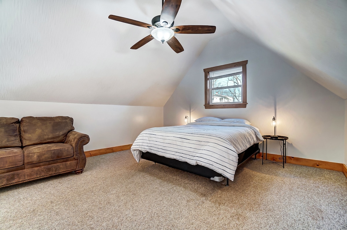 Bedroom 2 located in the upstairs open loft space features a queen bed and couch. 