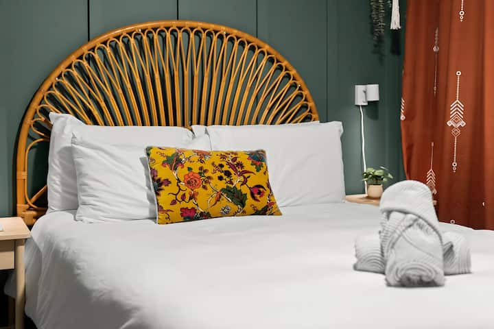 ห้องนอนที่มีสไตล์และได้รับแรงบันดาลใจจากโบโฮมีเตียงควีนไซส์พร้อมที่นอนเมมโมรี่โฟม Casper ผ้าปูที่นอนใหม่และไฟส่องสว่างสำหรับการพักผ่อนที่อบอุ่นและผ่อนคลาย ออกแบบมาอย่างพิถีพิถันเพื่อความสะดวกสบายและการพักผ่อน