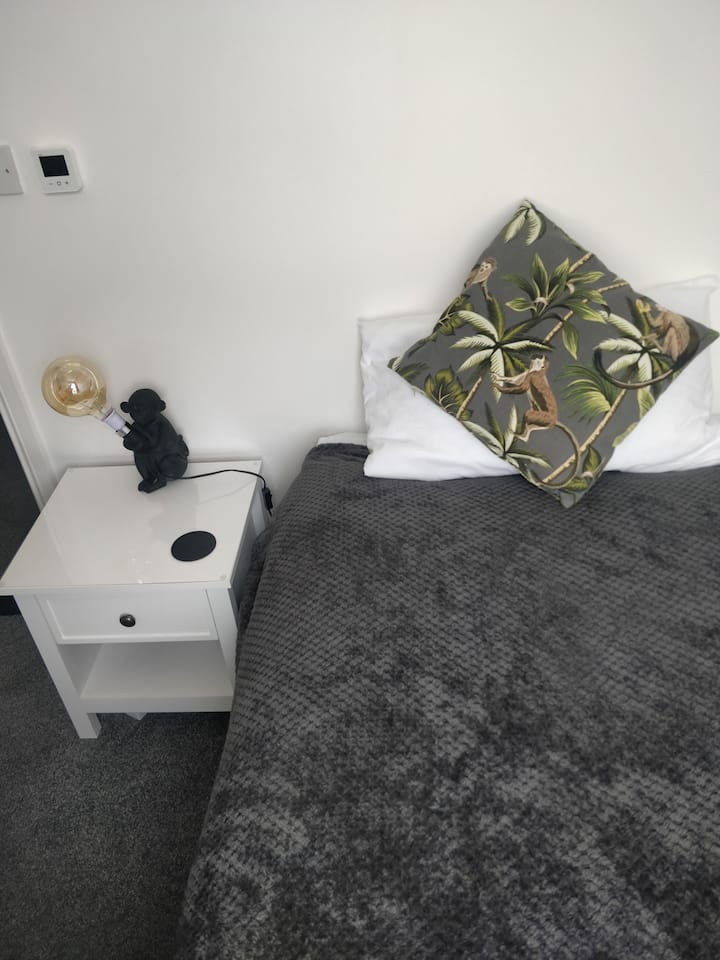 يقع سرير فردي مريح في الطابق العلوي في غرفة صندوق في الجزء الخلفي من المنزل، مما يوفر مساحة هادئة ومريحة.