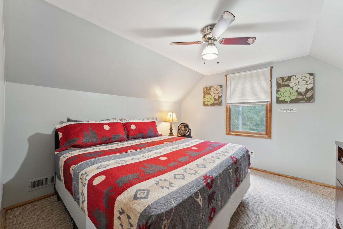 Dormitorio tamaño king en la cabaña de arriba con televisor Roku, cómoda, despertador con cargador USB, ventilador de techo, ventilador portátil, almohada y mantas adicionales y armario con perchas