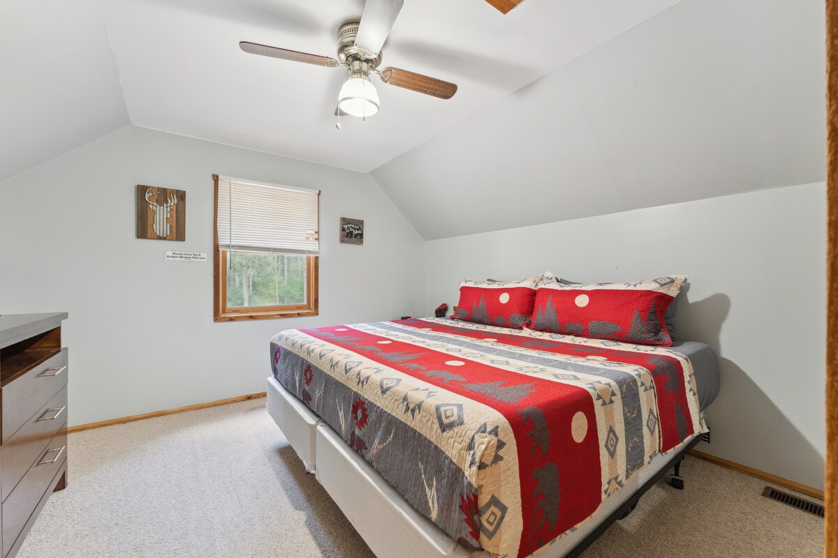Dormitorio tamaño king en la cabaña de arriba con televisor Roku, cómoda, despertador con cargador USB, ventilador de techo, ventilador portátil, almohada y mantas adicionales y armario con perchas