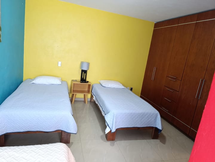 спалня с три единични легла, дрешник и телевизор 