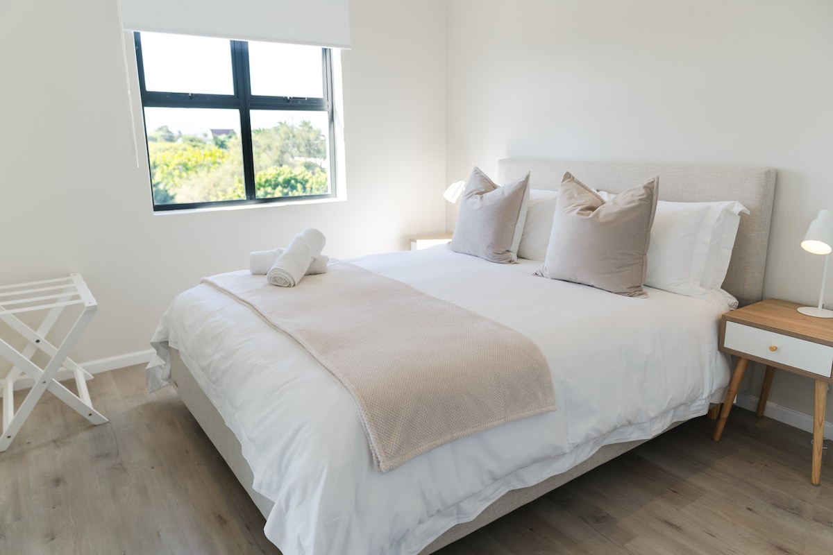 Bedroom with queen extra-length bed with Egyptian Cotton linen and a wardrobe.