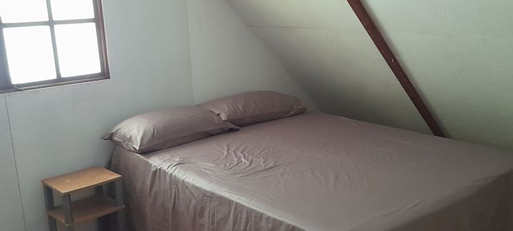 ห้องนอนขนาดใหญ่ชั้นบนที่ Chalet Miki-Miki ที่มีความเป็นไปได้ที่จะมีเตียงเดี่ยวรองรับได้ทั้งหมด 3 คนพร้อมวิวลากูน