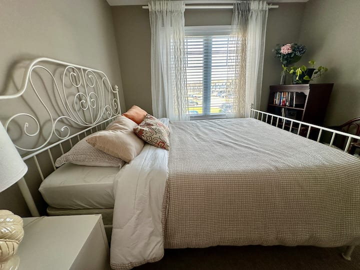 The Second Bedroom.  Queen bed with 2 side tables, lamp, clean beddings, towels,  closets, and with big windows to overlook the front street of the property.  Private bathroom just outside adjacent to the bedroom.