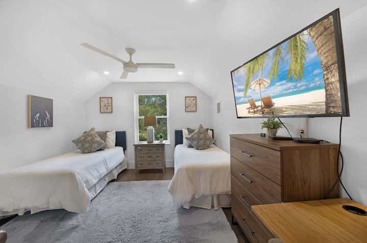 Cozy upstairs twin bedroom with large TV.