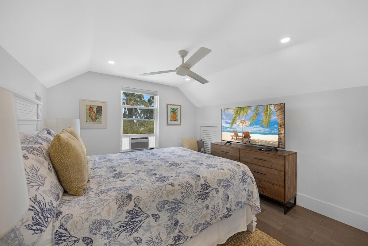 Spacious upstairs tropical themed bedroom, with king sized bed and large TV.