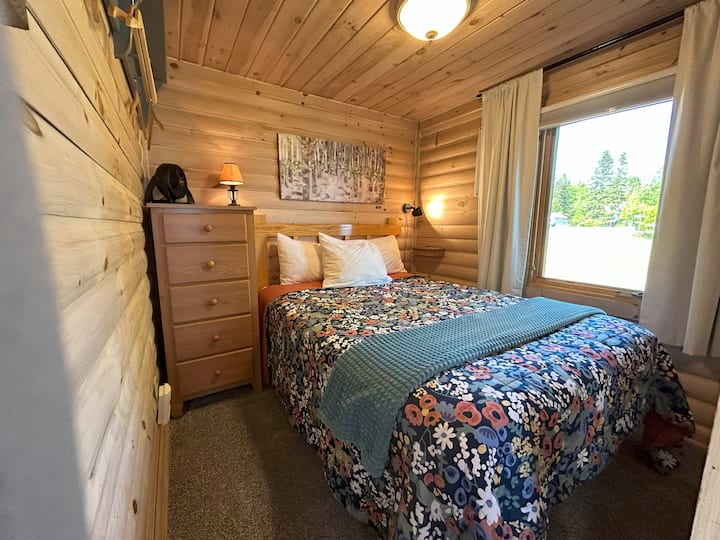 Cama cómoda de tamaño completo. Ten en cuenta que estas cabañas "minicasas" no tienen armarios, sino ganchos en las paredes y una pequeña cómoda para guardar tus pertenencias. 