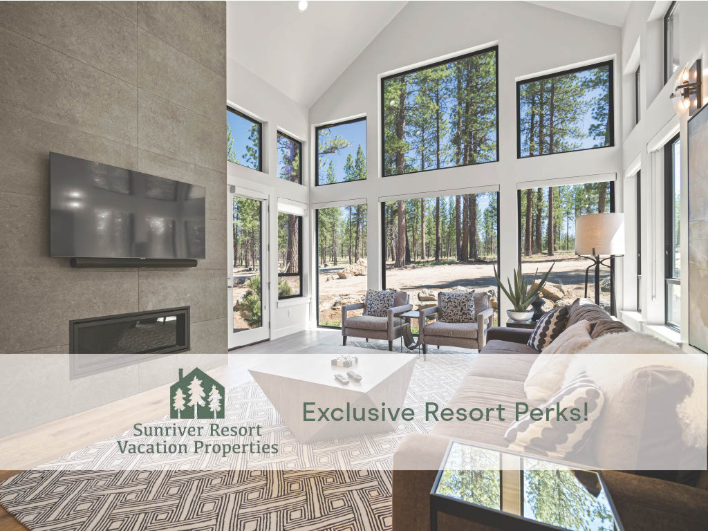 A great room is showcased with vaulted ceilings and large floor-to-ceiling windows, providing views of surrounding Ponderosa pines. A sleek gas fireplace is positioned beneath a wall-mounted TV. Cozy seating areas are arranged around a modern coffee table, inviting relaxation.