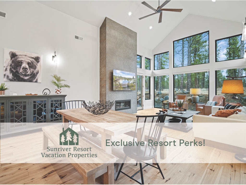 A spacious great room features tall vaulted ceilings and large floor-to-ceiling windows that allow natural light to fill the space. A modern gas fireplace is centered along the wall, with a welcoming dining table positioned nearby, surrounded by comfortable seating.