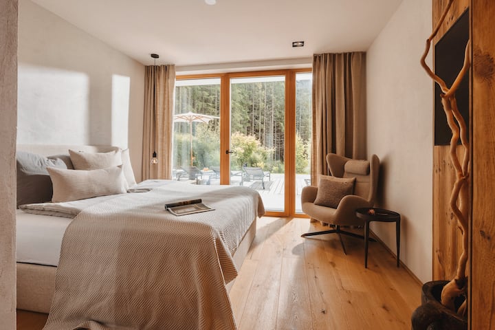 Die Pool-Suite | Im Erdgeschoss gelegen und mit direktem Zugang zur Terrasse: Die Pool-Suite verbindet Komfort mit Gartenidylle und führt Sie morgens barfuß direkt ins Grüne – oder in den beheizten Pool.

