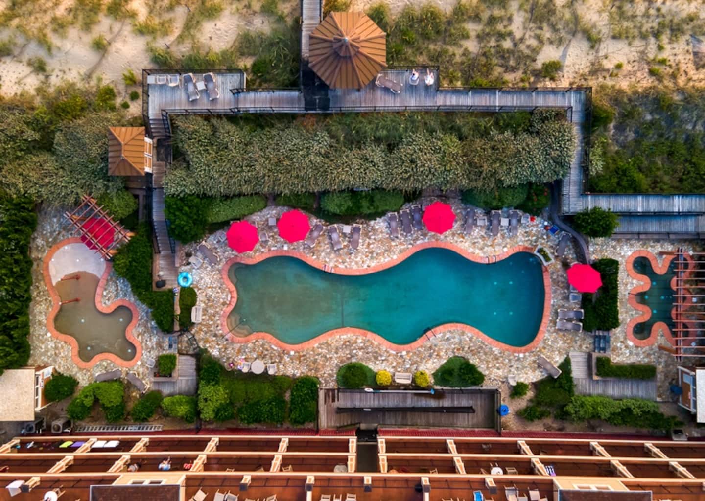 Looking down at the Croatan Surf Club outdoor pool deck, lounge chairs and landscaping steps from the door