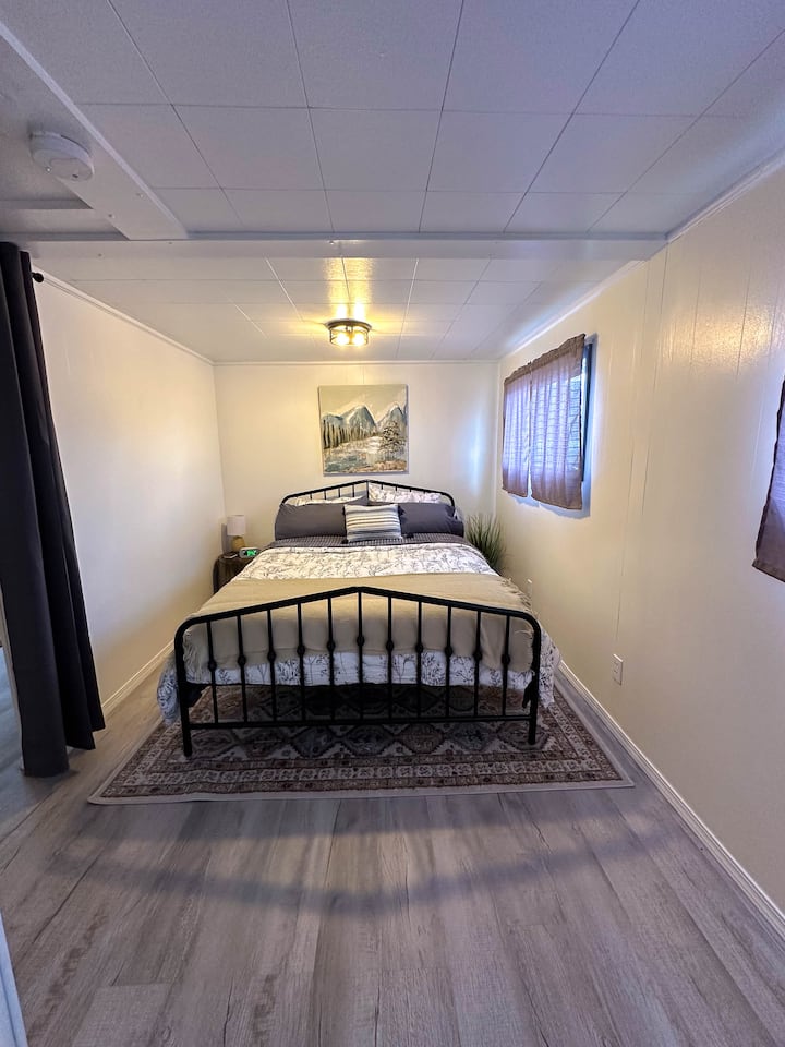 El dormitorio cuenta con una cómoda cama tamaño queen y vistas a la montaña desde las ventanas. Hay un pequeño armario con almohadas, mantas y toallas de baño adicionales. 