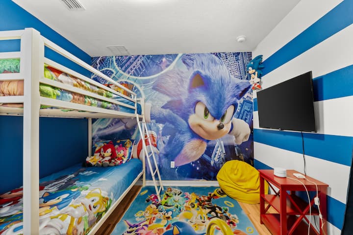  Zmadho argëtimin në dhomën tonë me tematikë zërit! Me 2 krevate të rehatshëm teke dhe dizajne të gjalla muri, është një hapësirë argëtuese ku fëmijët mund të pushojnë, të relaksohen dhe të imagjinojnë aventura me shpejtësi të lartë me heroin e tyre të preferuar blu. E përkryer për lojtarë dhe tifozë të rinj!