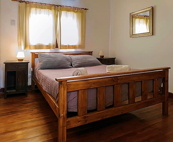 غرفة النوم الرئيسية المطلة على الحديقة. يحتوي على خزانة كبيرة وباب للحمام.