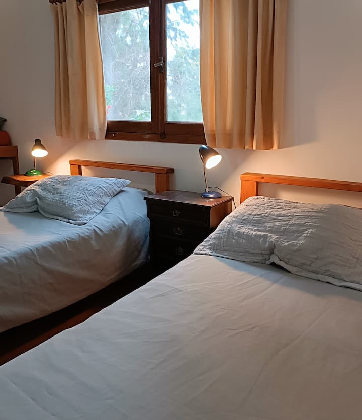 غرفة بسريرين مفردين وإطلالة على الحديقة