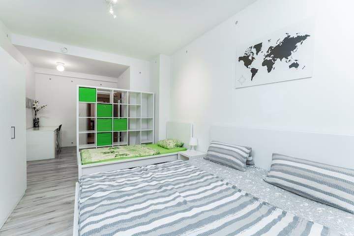 Chumba cha pili cha kulala chenye vitanda vya wageni 3, sehemu ya kuhifadhi, televisheni na dawati.