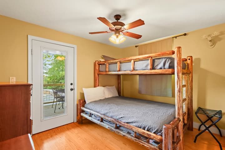 غرفة نوم بطابقين، السرير عبارة عن سرير مزدوج فوق سرير كوين. تحتوي الغرفة أيضًا على باب إلى الشرفة الجانبية اليسرى.