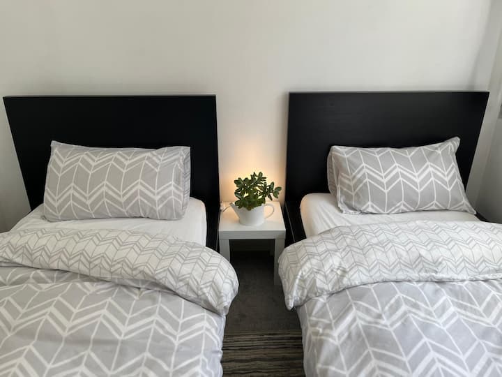 A large bedroom on the first floor with a desk, chair and two single beds. We call this the blue room.