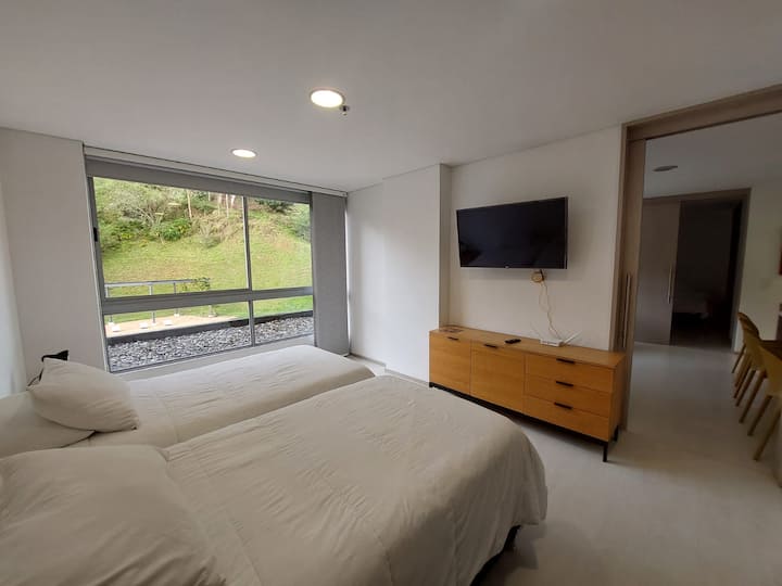 Pusho në këtë dhomë të rehatshme me dritare që e mbushin hapësirën me dritë natyrale dhe një pamje relaksuese të gjelbër. Ideale për shkëputjen dhe rimbushjen e energjisë në një mjedis të qetë dhe të freskët.