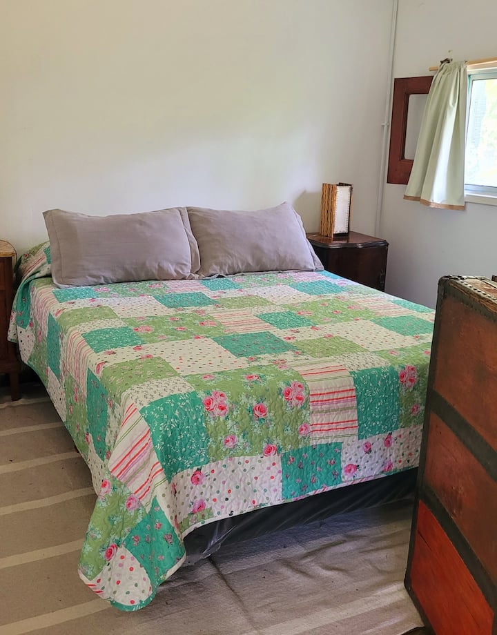 habitacion con cama doble con somier y vista al río