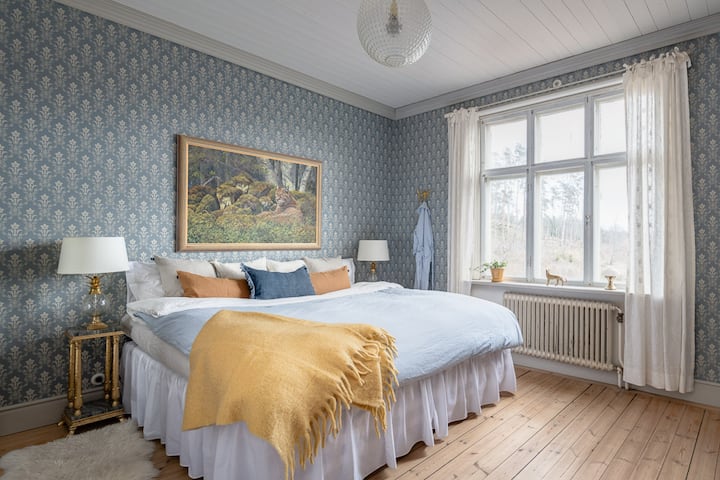 Masterbedroom har en stor säng som är 200x200 cm stor. Utsikt mot äppelträdgård, skog, åkrar och ladugård. 