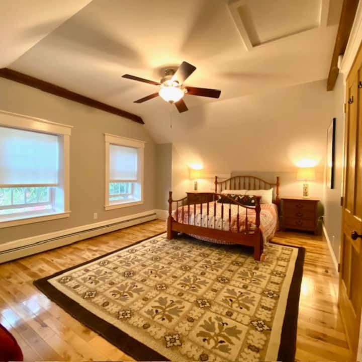 Large room with a queen size bed and couch area. 