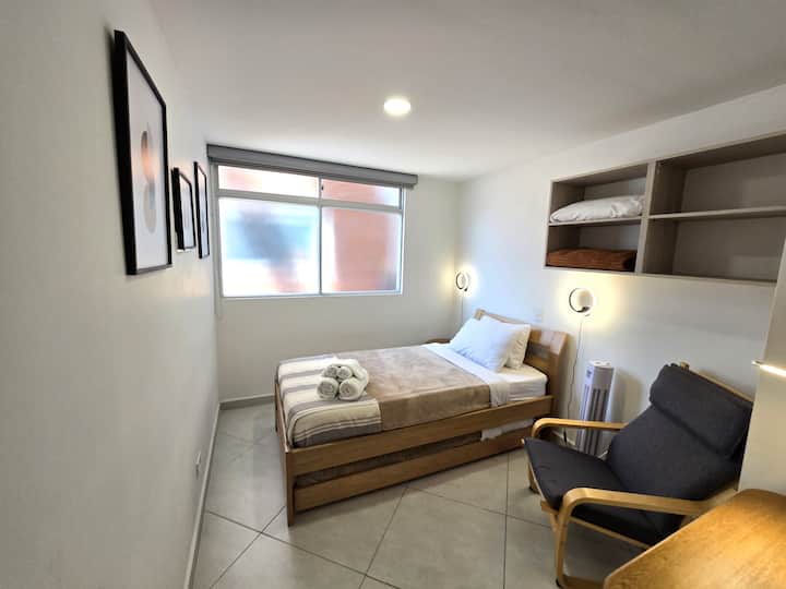 Perfecta para grupos o familias: dos camas cómodas, una repisa funcional y un sillón acogedor para relajarte.