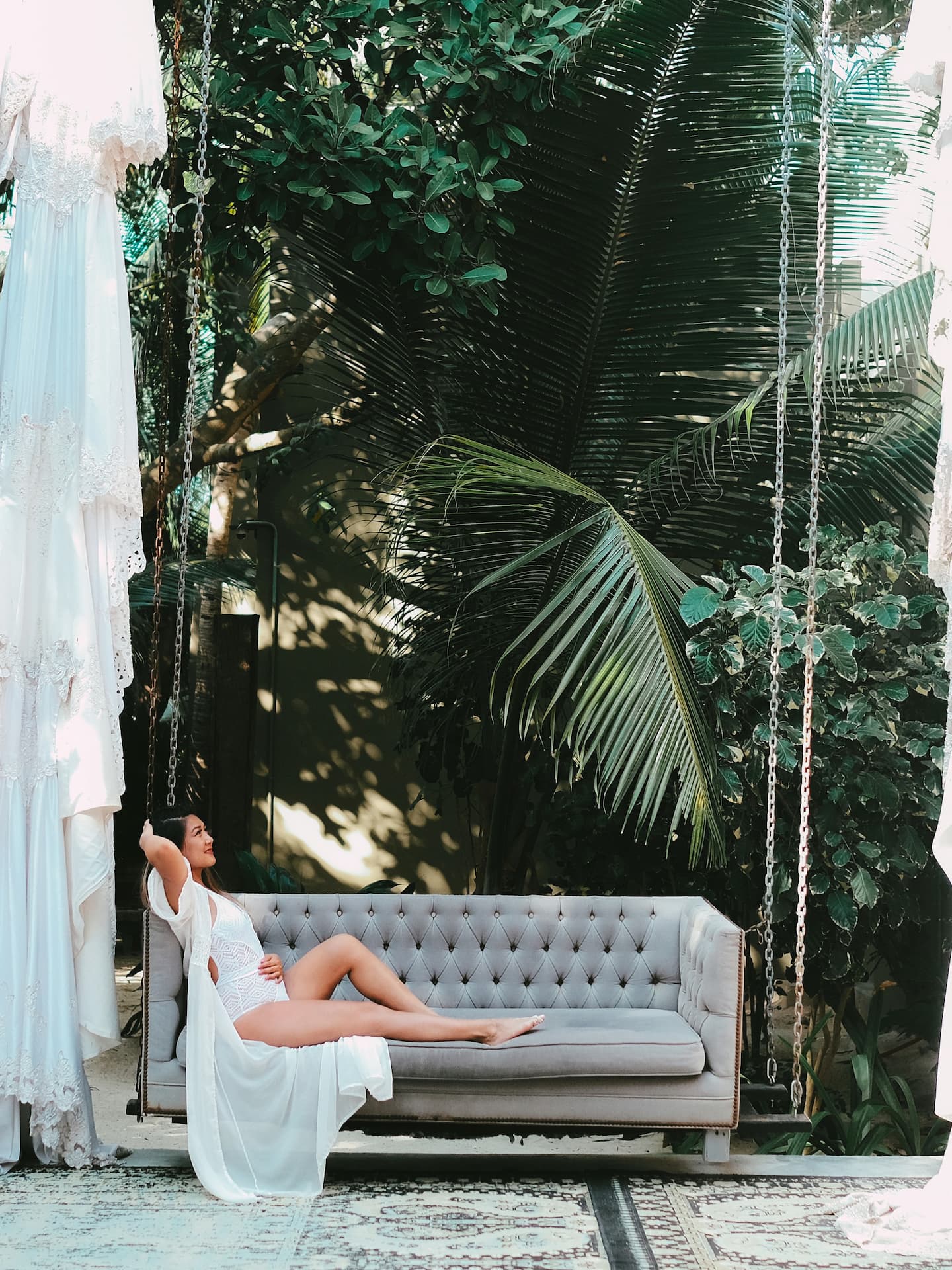 woman in white bathing suit on a hanging couch in tulum mexico