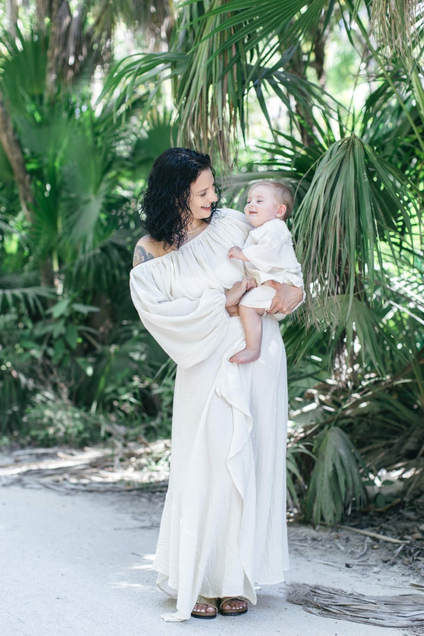 mom in white dress carrying her child during a photoshoot in Tulum
| best things to do in Tulum with kids