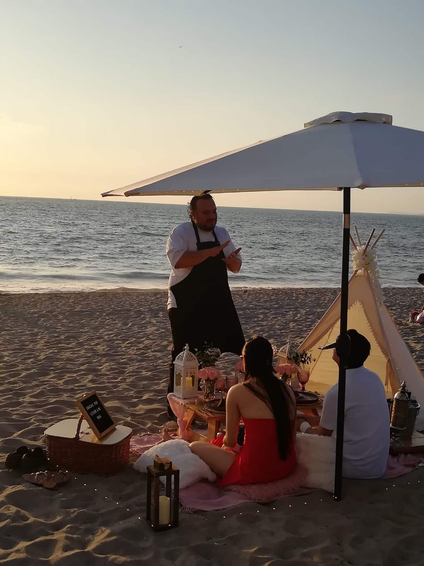 chef talking to guests during a cooking class by the beach