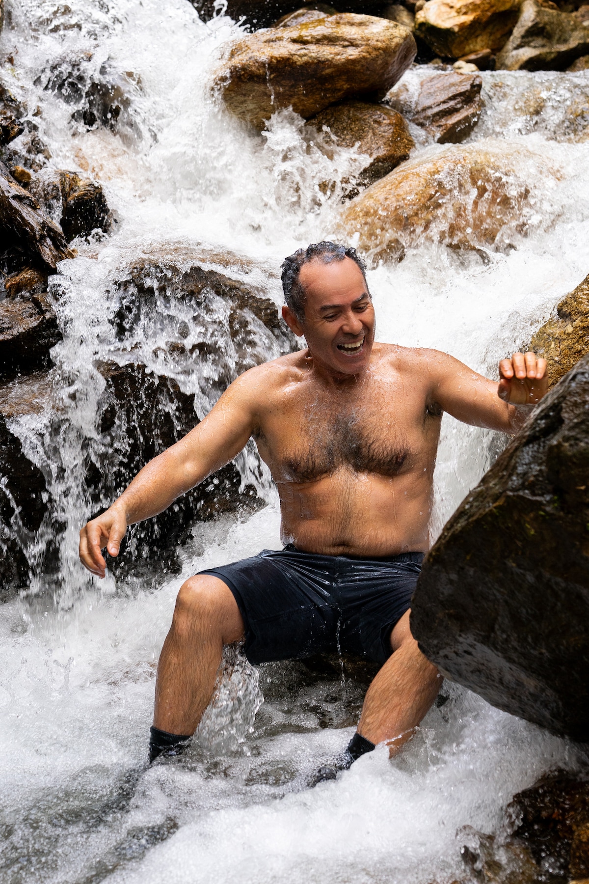 Meditiere unter einem Wasserfall in einer natürlichen Umgebung