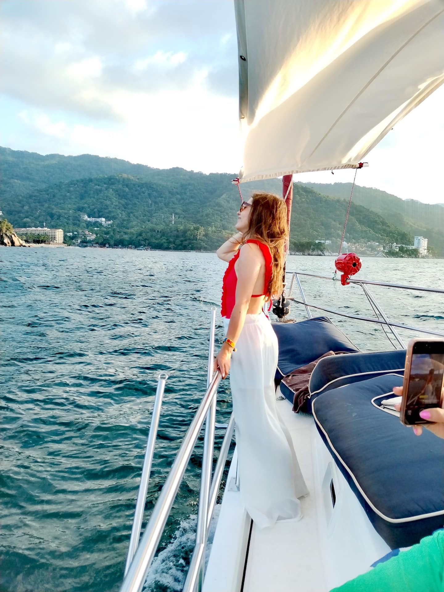 girl in red bikini and white pants posing for a picture in a yacht