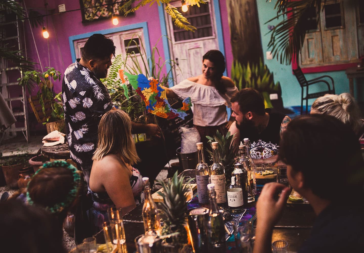 group of guests listening to the host talking about mezcal