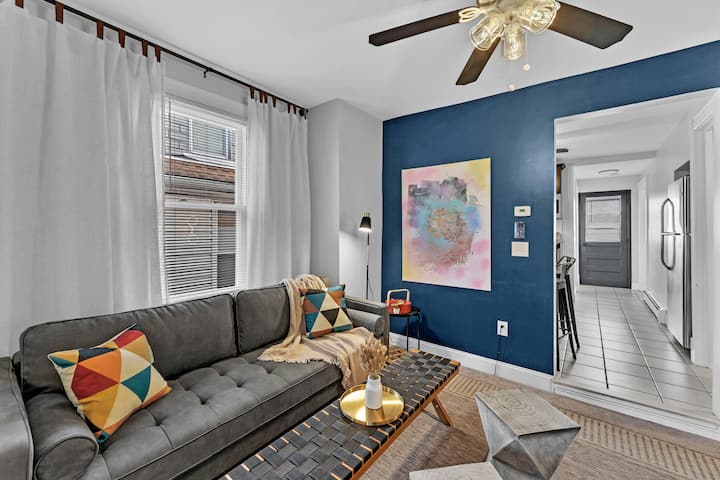 Отпуснете се в тази привлекателна всекидневна с плюшен диван, елегантна масичка за кафе и прохладен вентилатор.