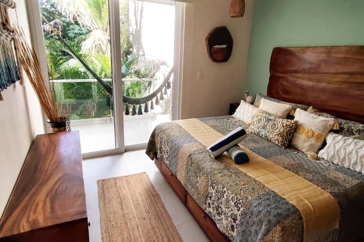 Unwind in style: a room adorned with built-in closets and a luxurious king-size bed, offering a view of the lush jungle garden. Experience ultimate comfort amidst nature's embrace, where every detail is designed for your serene retreat.