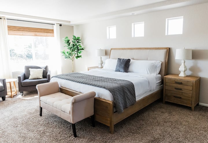 Dormitorio luminoso con amplia ventana y cómodo sofá.