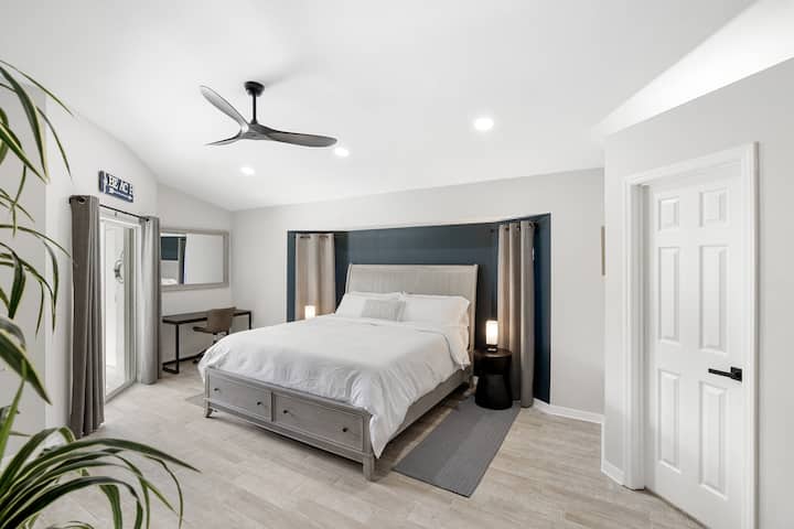 Hlavná spálňa s manželskou posteľou, vlastným vchodom do bazéna, 65-palcovou TV a 2 šatníkmi spolu s vlastnou hlavnou kúpeľňou 