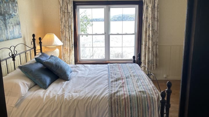 חדר שינה יפהפה עם מיטת קווין סייז ונוף נהדר לאגם.